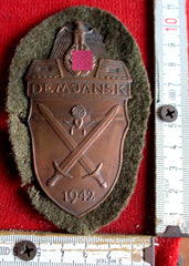 Wehrmacht Ostfront Demjansk - Schild 1942 Eisen getönt, auf feldgrauer Unterlage mit Rückenplatte, ohne Papierabdeckung